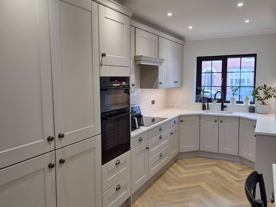 Light grey shaker kitchen with quartz worktops and herringbone flooring