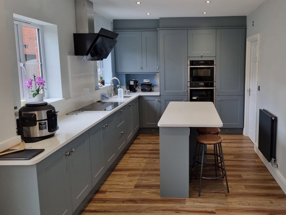 Blue-grey shaker kitchen with white quartz breakfast island and double oven